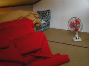 毛布や布団の小山とミニ扇風機